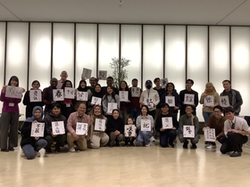 A group photo with students’ calligraphy and smiles