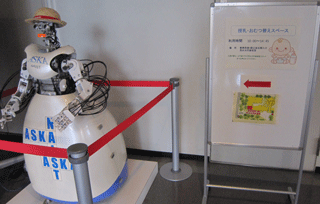人型ロボット横の授乳・オムツ替えスペース案内板の写真