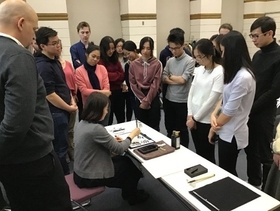 Participating students watching Ms. Matsui demonstrate different calligraphy writing styles