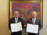 （左から）協定書を掲げる横矢直和学長、橋本隆史 南都銀行取締役頭取